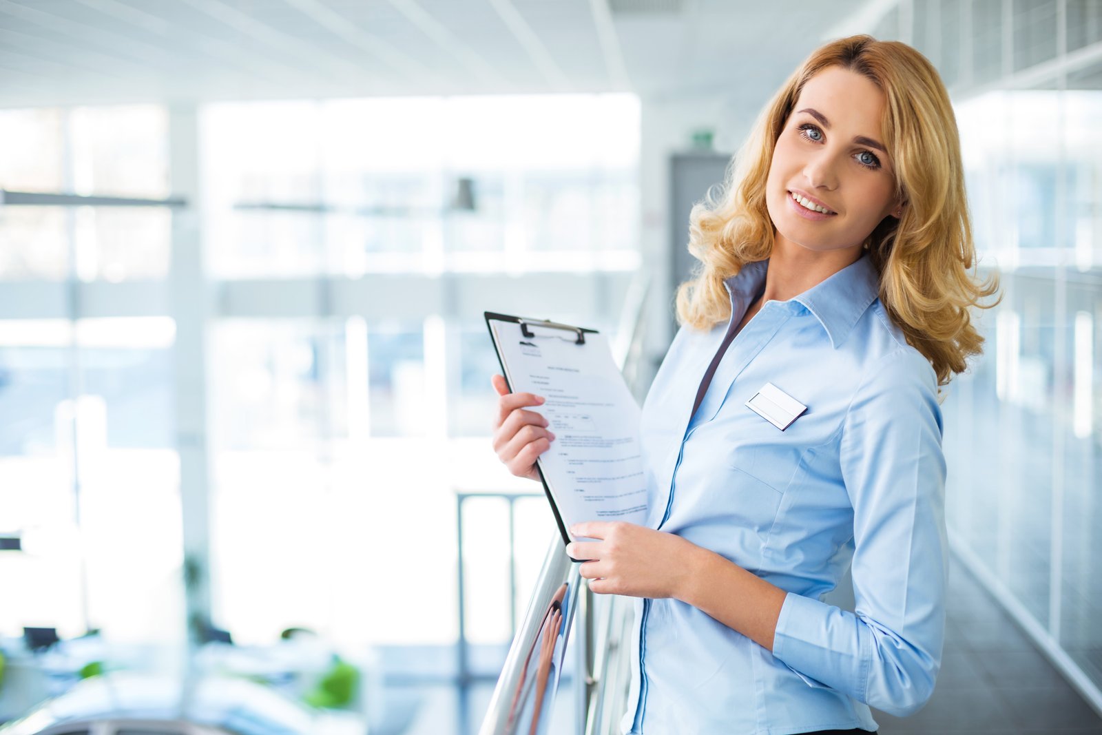 International patient coordinator holding a clipboard in a bright office